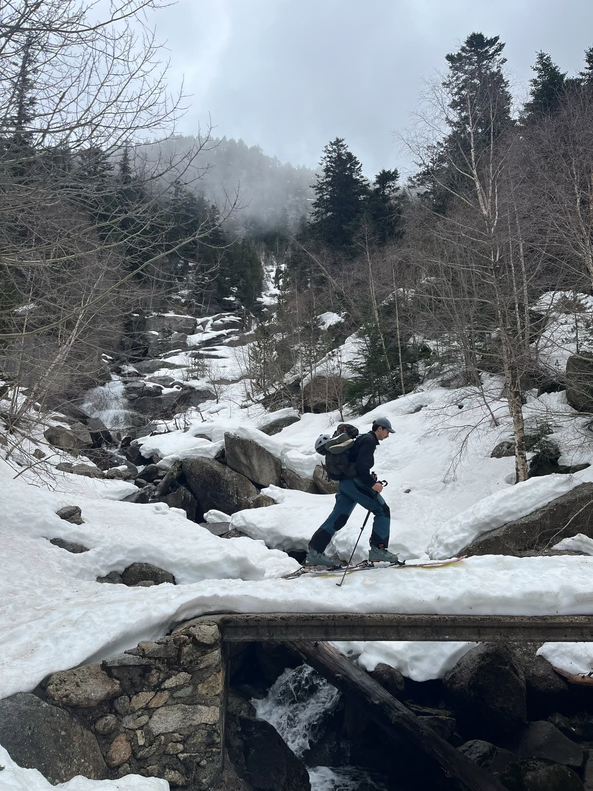 Cruzando un puente de madera entre el bosque nevado
